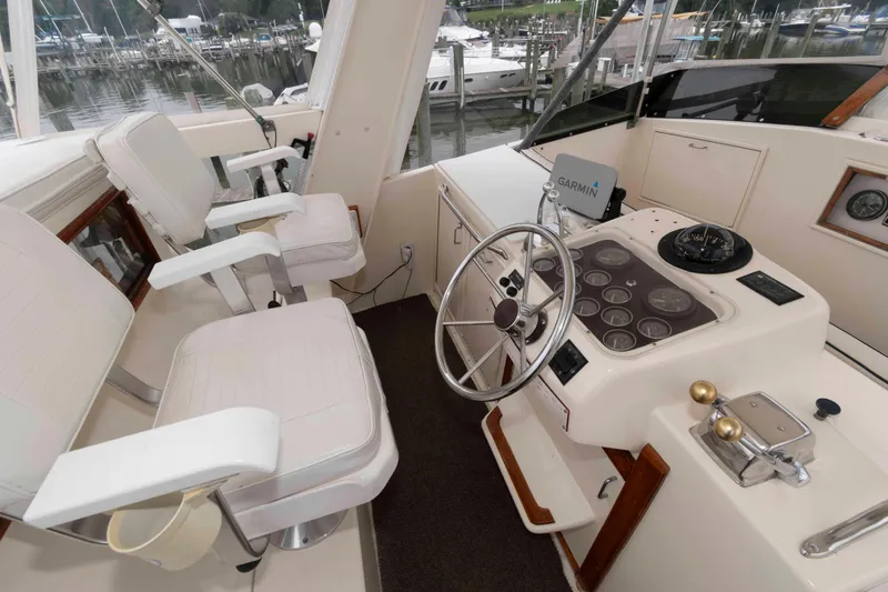 Slide: The Image of 1985 Ocean Yachts 46 Sunliner helm with steering wheel, gauges, and Garmin navigation system. - 5