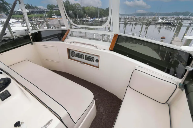 Slide: The Image of 1985 Ocean Yachts 46 Sunliner cockpit with seating, overlooking marina and calm waters. - 7