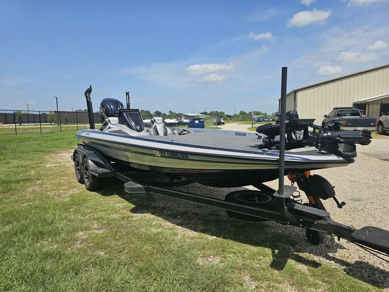 Slide: The Image of 2025 Skeeter FXR21 PRO bass boat on trailer, parked outdoors under clear sky. - 14