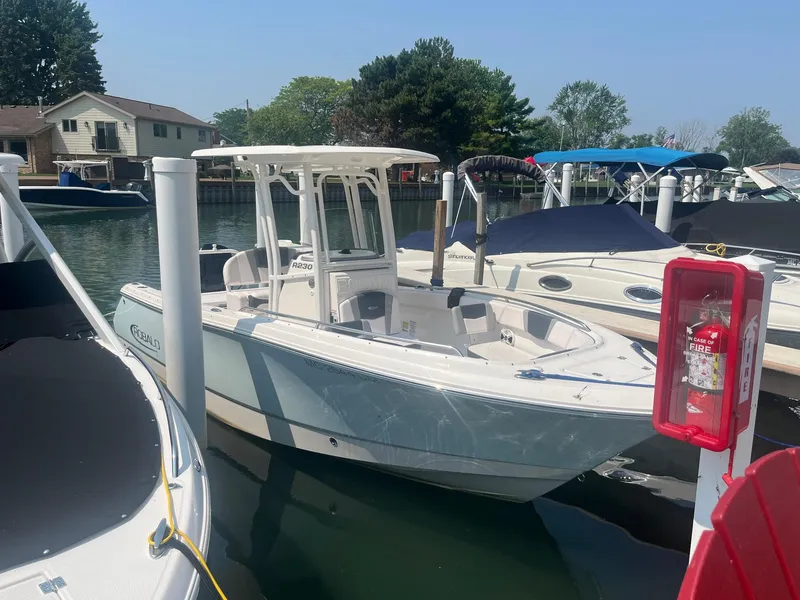 Slide: The Image of 2020 Robalo R230 Center Console boat docked in a marina, surrounded by other boats. - 1