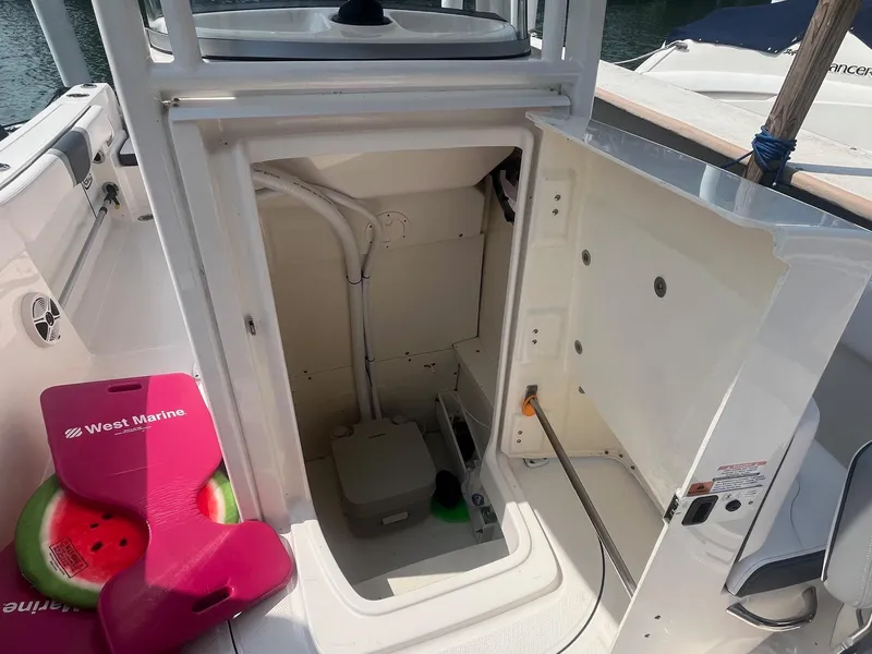 Slide: The Image of 2020 Robalo R230 Center Console boat storage compartment with marine equipment and accessories. - 14