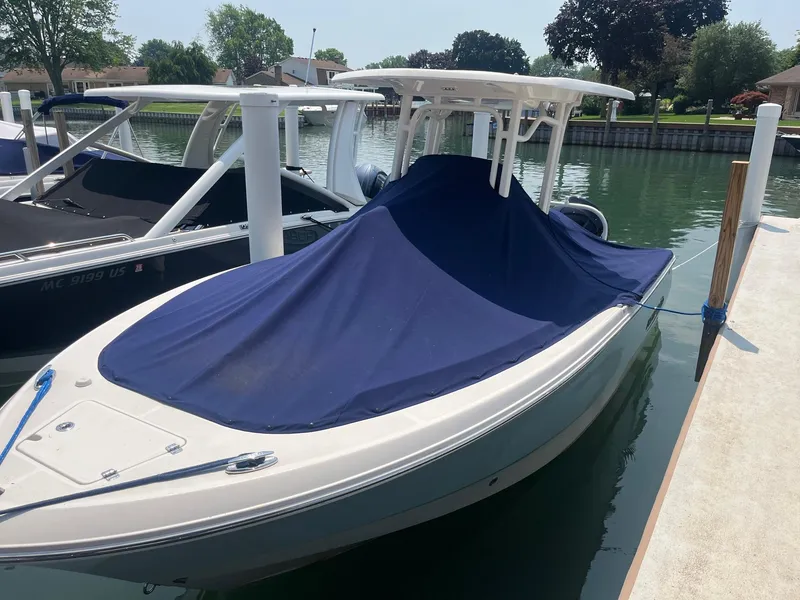Slide: The Image of 2020 Robalo R230 Center Console boat docked with blue cover. - 16