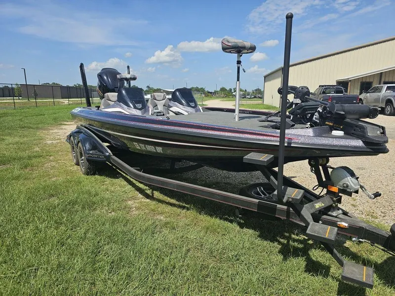Slide: The Image of 2017 Skeeter FX21 LE bass boat on trailer, parked on grass under a clear blue sky. - 12