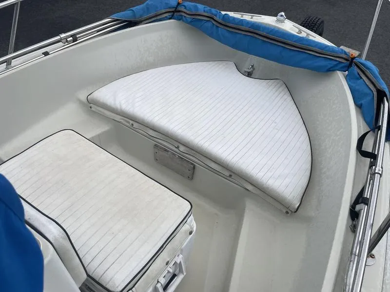 Slide: The Image of 1991 Boston Whaler 17 Outrage boat interior with white cushioned seating and blue trim. - 3