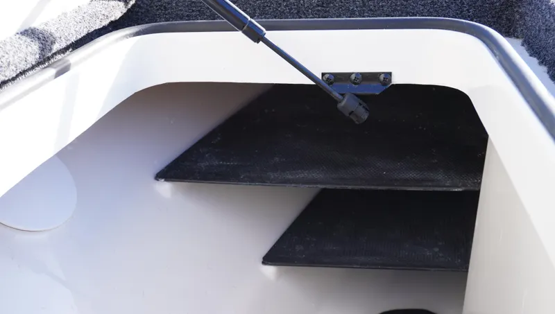 Slide: The Image of Interior view of 2025 Ranger Z520 boat storage compartment with black shelves. - 13