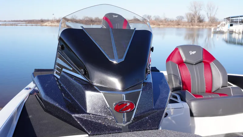 Slide: The Image of 2025 Ranger Z520 boat with sleek design and red-accented seats on a calm lake. - 2