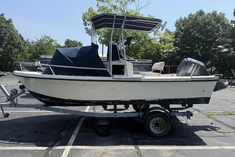 Slide: The Image of 1996 Parker 18 CC boat on trailer in parking lot, side view. - 5