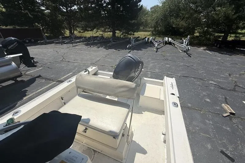 Slide: The Image of 1996 Parker 18 CC boat with seating, parked on asphalt near trees. - 6