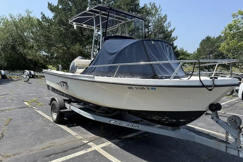 Slide: The Image of 1996 Parker 18 CC boat on trailer in parking lot, covered and ready for transport. - 8