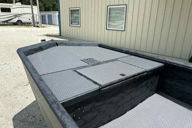 Slide: The Image of 2025 Gator Tail 1860 Extreme boat with textured deck, parked near a building. - 1