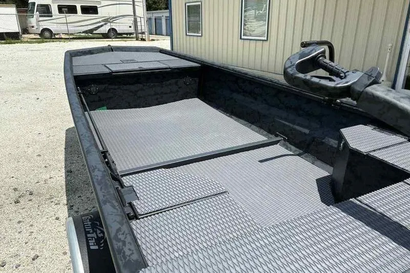 Slide: The Image of 2025 Gator Tail 1860 Extreme boat with textured flooring, parked near a building. - 12