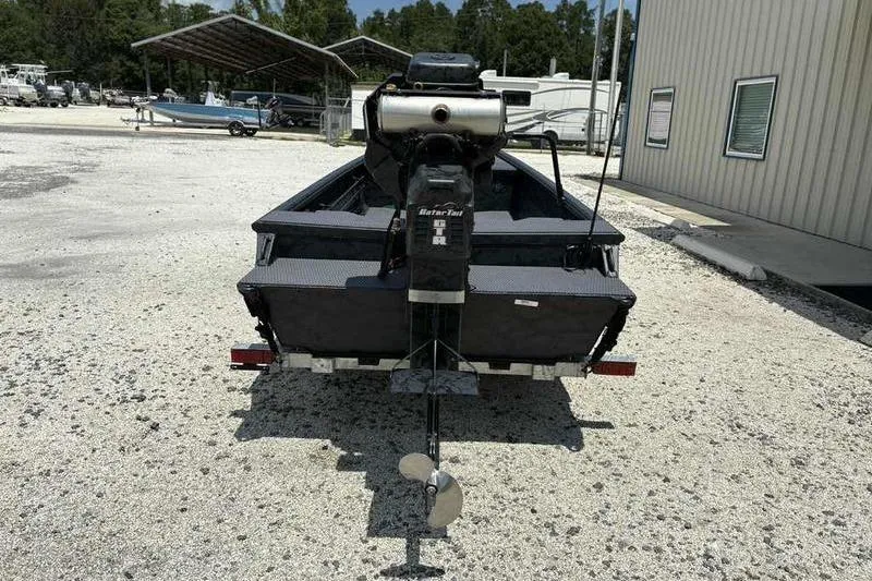 Slide: The Image of 2025 Gator Tail 1860 Extreme boat with motor, parked outdoors on gravel. - 7