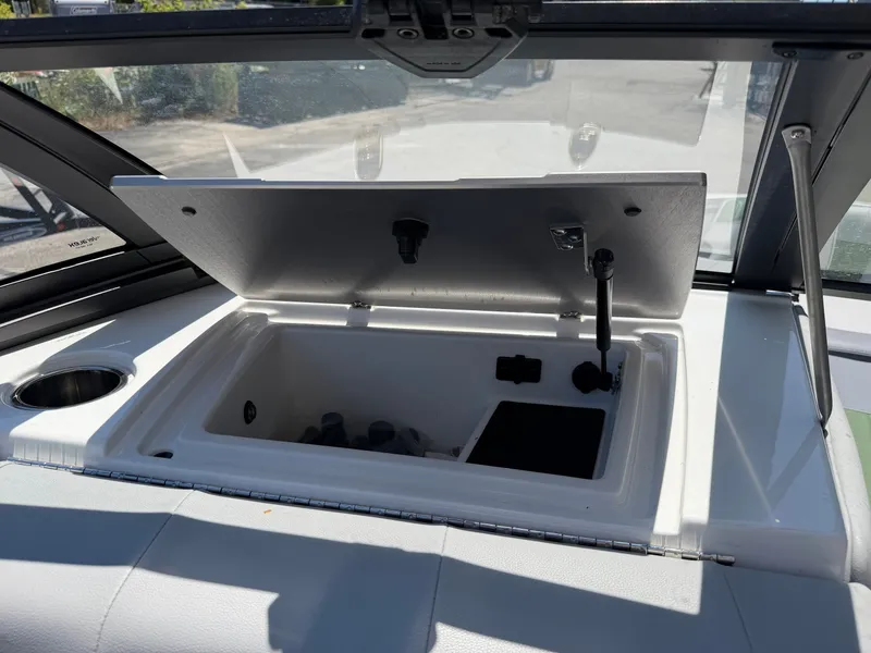 Slide: The Image of An open storage compartment on a boat with a cup holder beside it. - 42