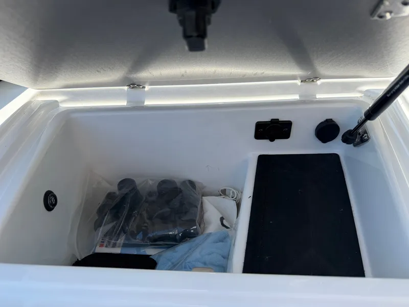 Slide: The Image of An open storage compartment on a boat with various items, including a bag and a towel. - 43