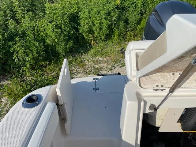 Slide: The Image of 2016 Robalo 2220 Center Console boat with open hatch, near greenery. - 14
