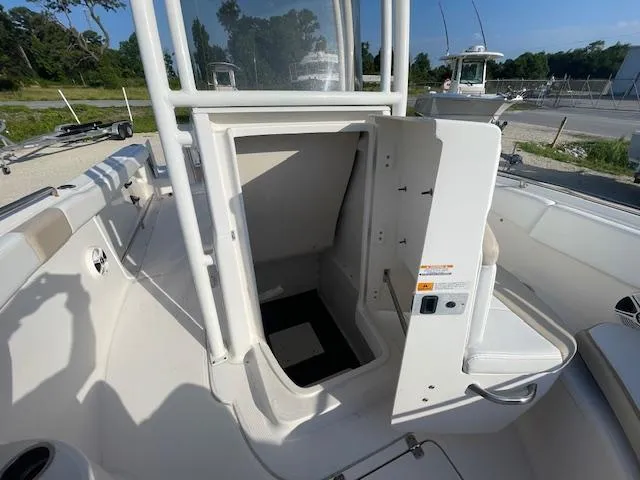 Slide: The Image of 2016 Robalo 2220 Center Console boat with open storage compartment, docked outdoors. - 17