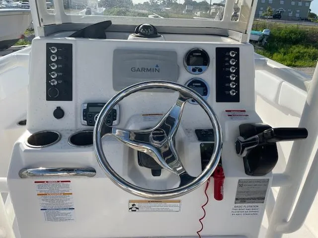 Slide: The Image of 2016 Robalo 2220 Center Console boat dashboard with Garmin navigation system and steering wheel. - 18