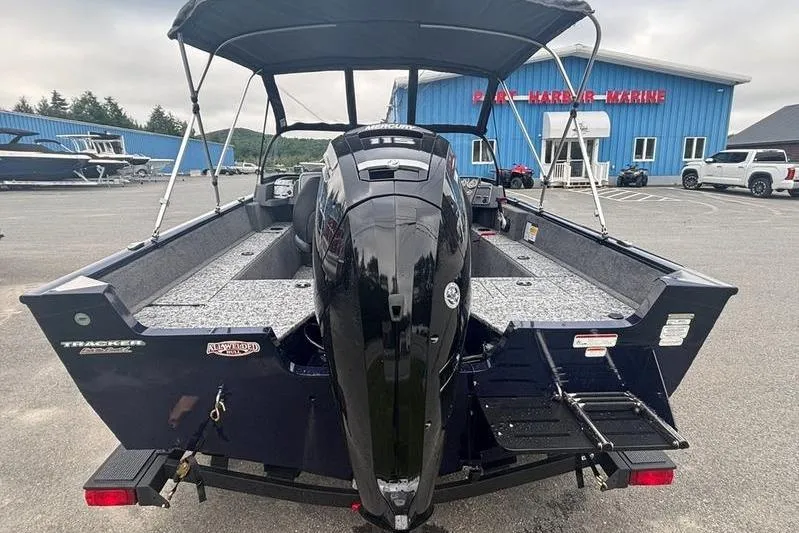 Slide: The Image of 2026 Tracker PG V175 WT boat with outboard motor, parked at a marine dealership. - 7