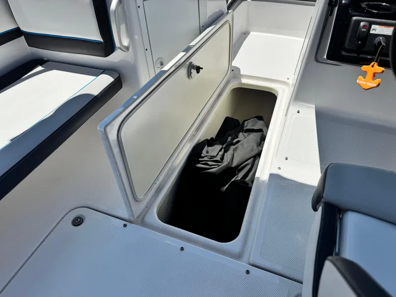 Slide: The Image of 2020 Yamaha AR195 boat interior storage compartment with open hatch and black fabric inside. - 21