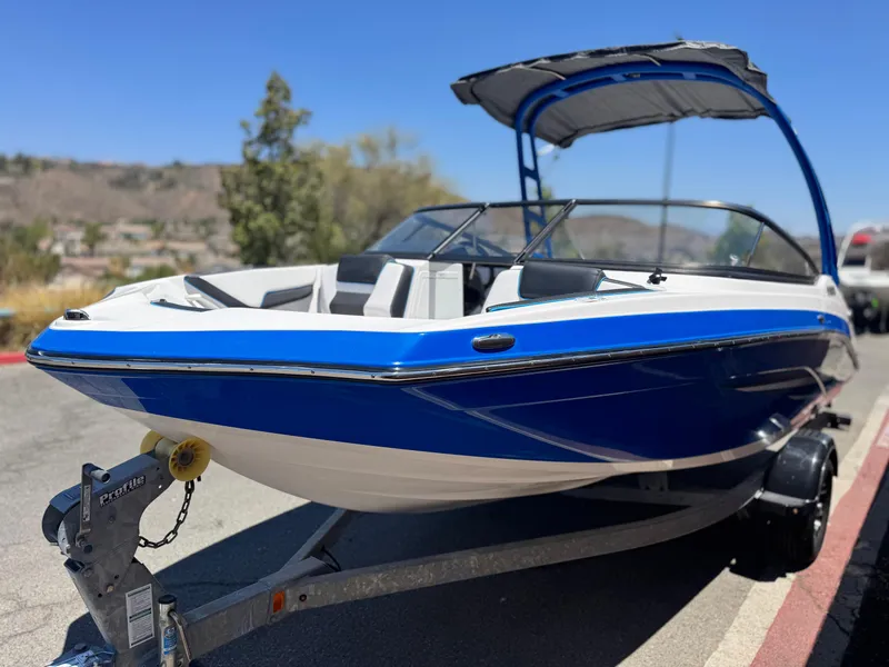 Slide: The Image of 2020 Yamaha Boats AR195, blue and white, on trailer, sunny day. - 3