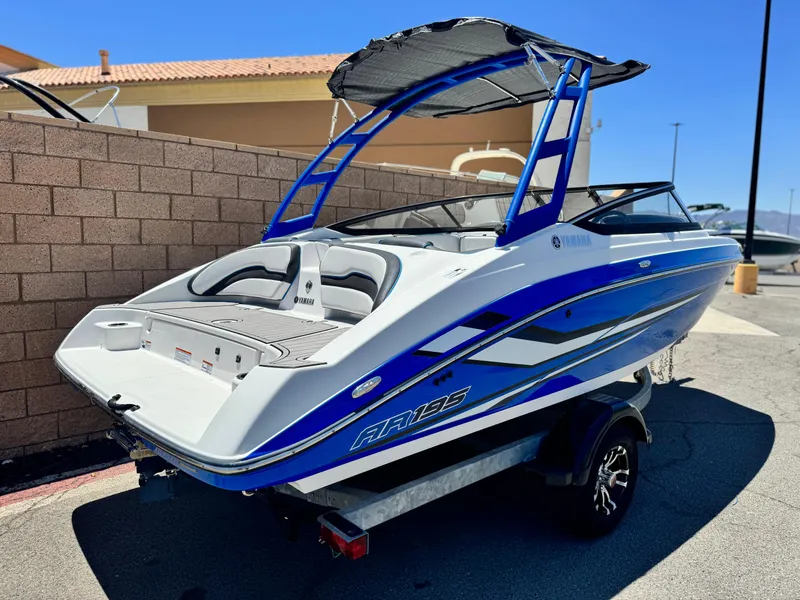 Slide: The Image of 2020 Yamaha Boats AR195 on trailer, blue and white design, parked outdoors. - 5