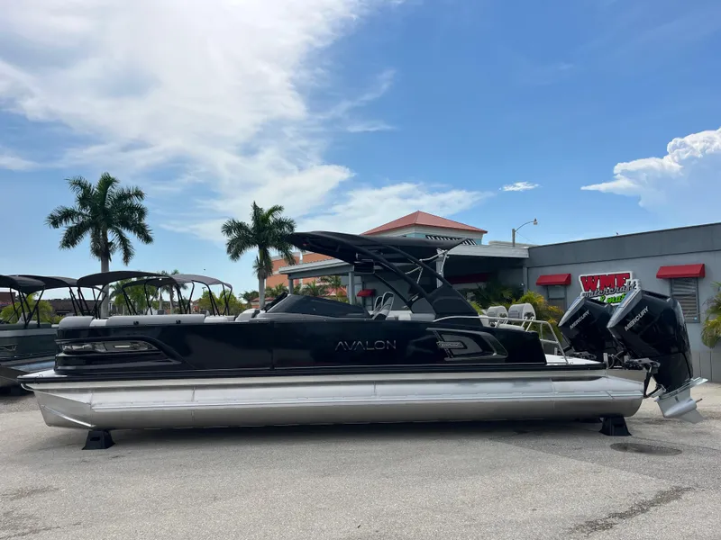 Slide: The Image of Avalon 2785 Excalibur LTD boat with twin Mercury 400hp engines, parked outdoors. - 8