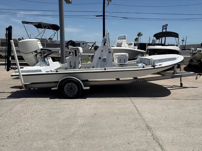 Slide: The Image of Custom 2013 boat on trailer in marina, surrounded by other boats under clear sky. - 3
