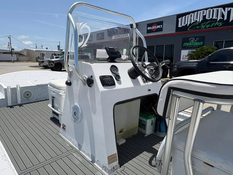 Slide: The Image of Center console of a 2013 Custom boat, featuring steering wheel and controls, at Waypoint Customs. - 7