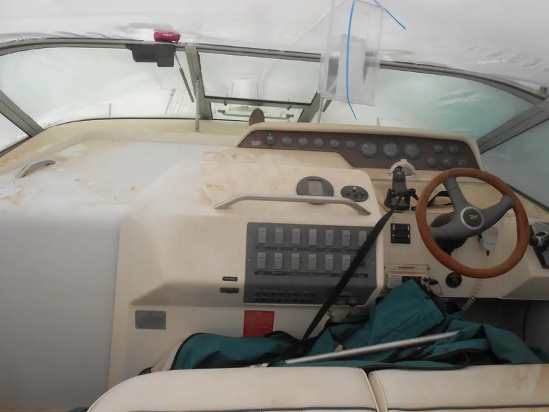 Slide: The Image of 1996 Sea Ray 290 Sundancer helm with steering wheel and control panel. - 11