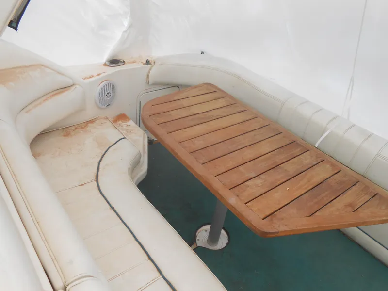 Slide: The Image of 1996 Sea Ray 290 Sundancer interior with wooden table and white seating. - 12
