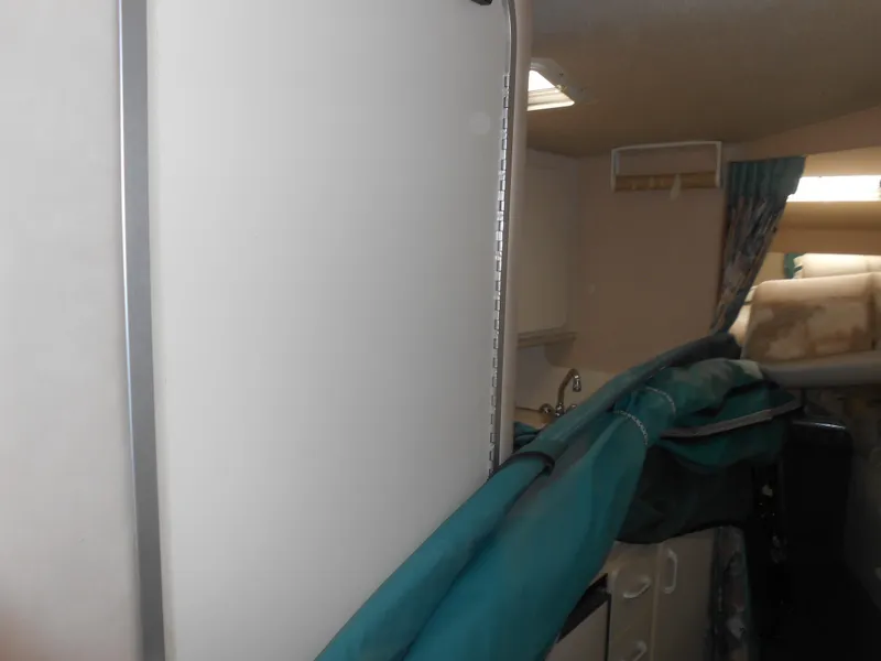 Slide: The Image of Interior of 1996 Sea Ray 290 Sundancer with sink, storage, and teal fabric. - 18