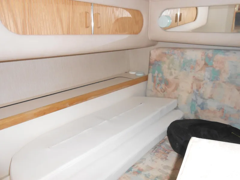 Slide: The Image of 1996 Sea Ray 290 Sundancer cabin interior with wood accents and patterned upholstery. - 25