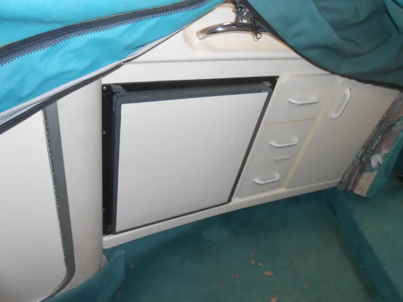 Slide: The Image of 1996 Sea Ray 290 Sundancer interior with compact kitchenette and storage drawers. - 27