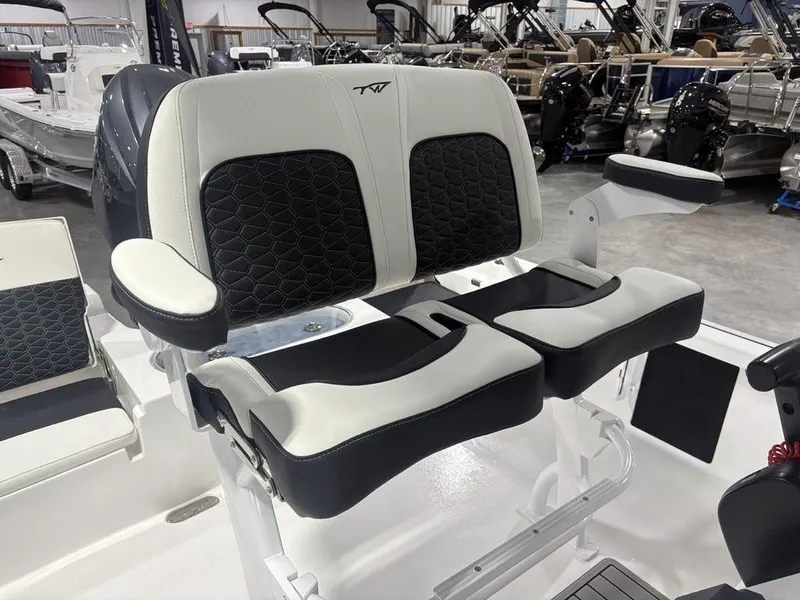Slide: The Image of 2026 Tidewater 2110 BM boat seats with black and white upholstery in a showroom. - 19