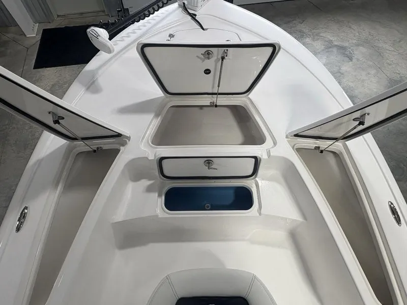 Slide: The Image of 2026 Tidewater 2110 BM boat with open storage compartments and sleek white design. - 9