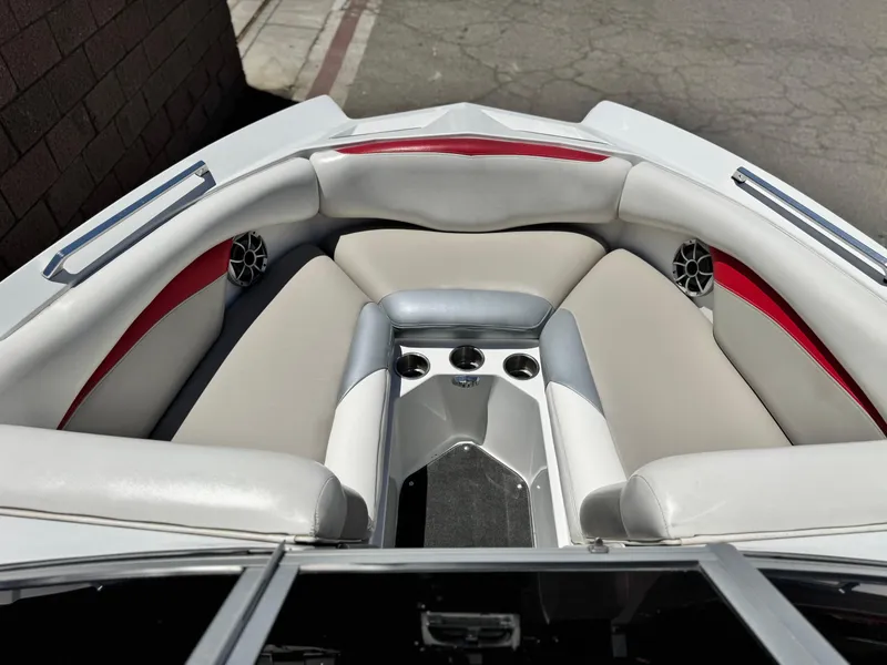 Slide: The Image of 2008 Tigé RZ2 boat interior with gray and red seating, cup holders, and speakers. - 16