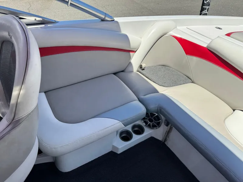 Slide: The Image of 2008 Tigé RZ2 boat interior with gray and red seating, cup holders, and speaker. - 21