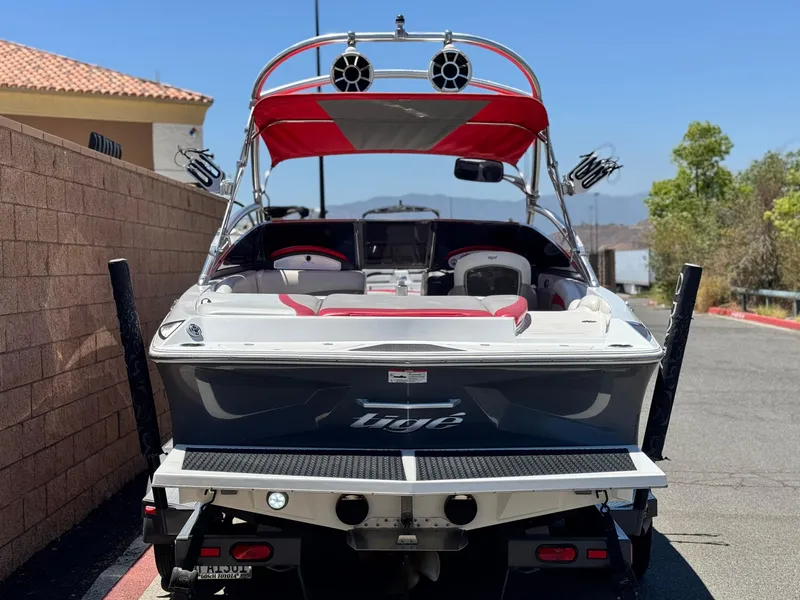 Slide: The Image of 2008 Tigé RZ2 boat with red accents parked near a brick wall. - 4