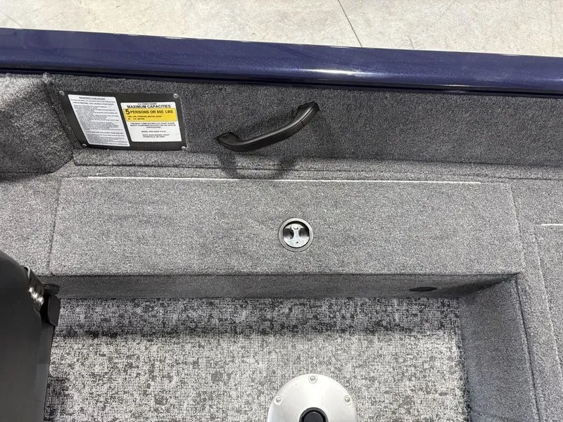 Slide: The Image of Interior of 2026 Tracker Pro Guide™ V-16 SC boat, featuring carpeted flooring and seating capacity label. - 18
