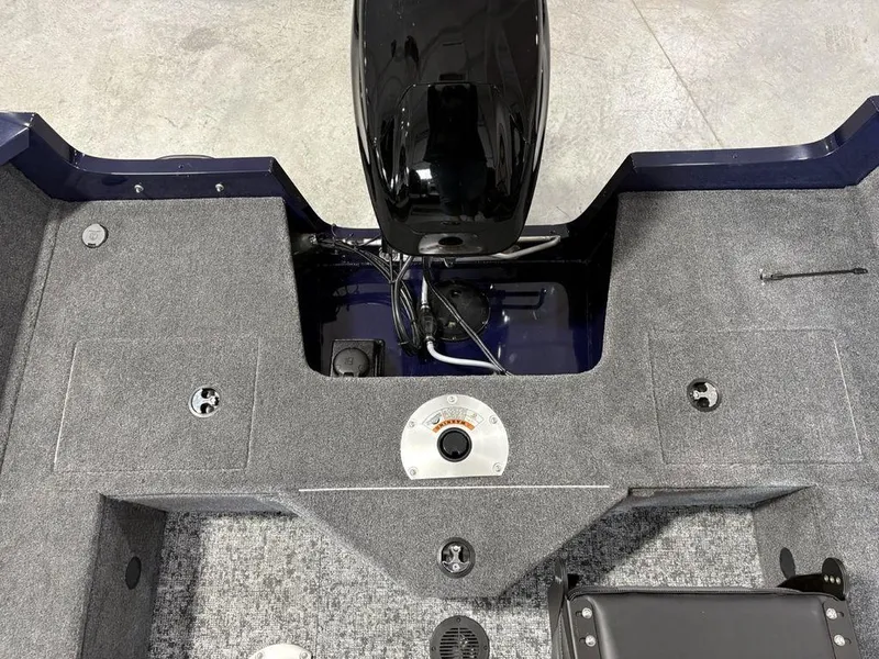 Slide: The Image of 2026 Tracker Pro Guide™ V-16 SC boat interior with motor and carpeted deck. - 21