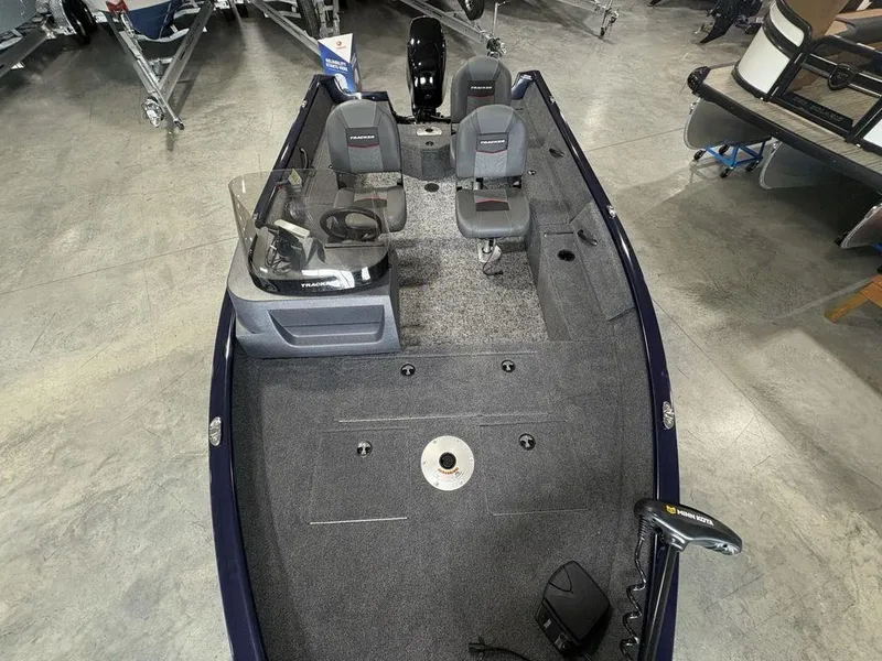 Slide: The Image of 2026 Tracker Pro Guide™ V-16 SC boat interior with seating and controls, displayed in showroom. - 22