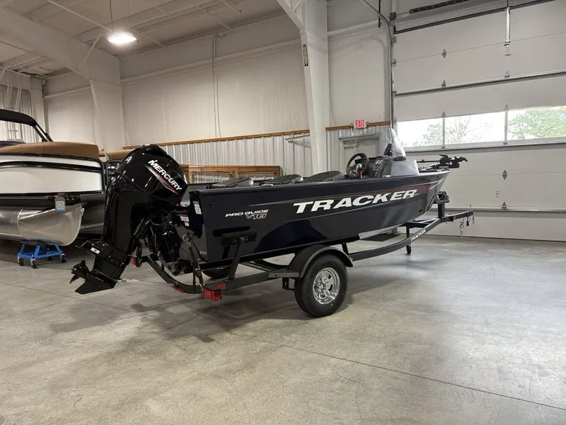 Slide: The Image of 2026 Tracker Pro Guide V-16 SC boat in a garage, featuring a Mercury outboard motor. - 3
