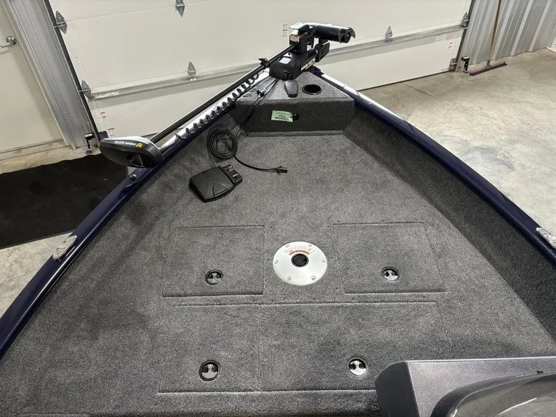 Slide: The Image of 2026 Tracker Pro Guide™ V-16 SC boat interior with trolling motor and carpeted deck. - 5