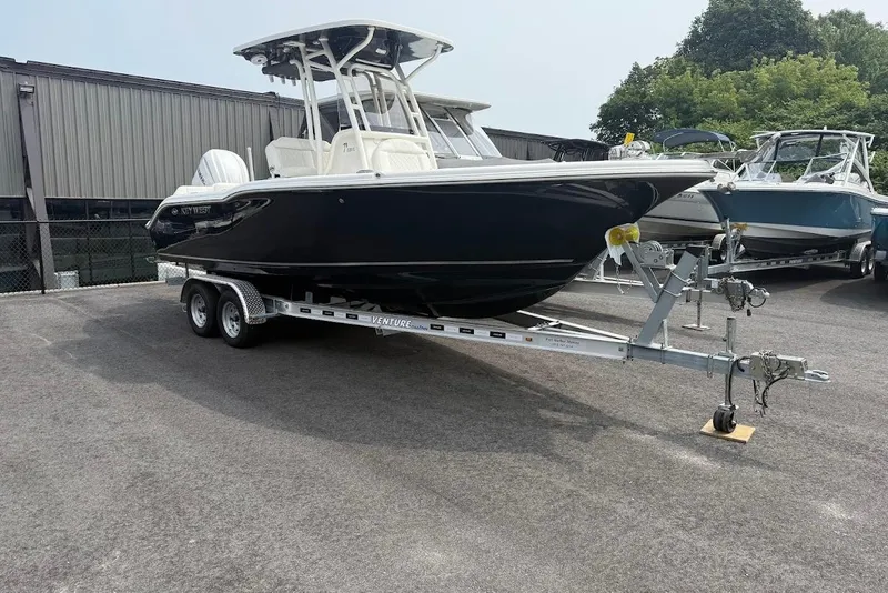 Slide: The Image of 2026 Key West 239 FS boat on trailer, parked outdoors near other boats. - 2