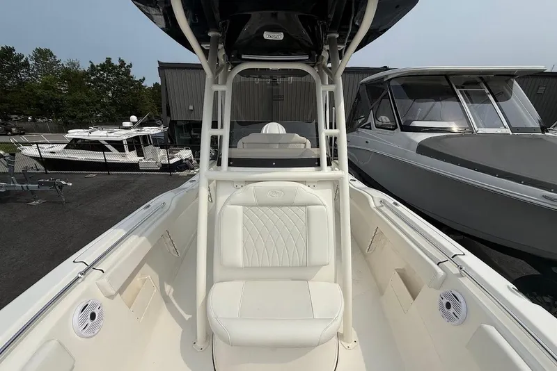 Slide: The Image of 2026 Key West 239 FS boat interior with seating and console, docked near other boats. - 6