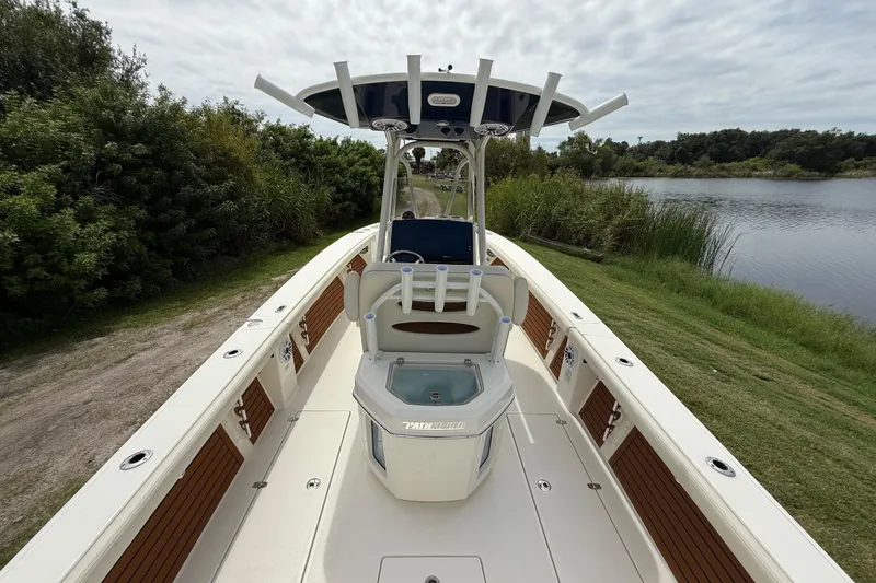 Slide: The Image of 2026 Pathfinder 2700 Open boat on a scenic lakeside, showcasing sleek design and spacious deck. - 12