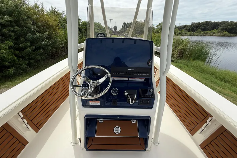 Slide: The Image of 2026 Pathfinder 2700 Open boat console with steering wheel, controls, and scenic waterway view. - 14