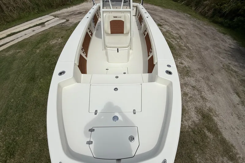 Slide: The Image of 2026 Pathfinder 2700 Open boat, spacious deck view, parked on grassy terrain. - 17
