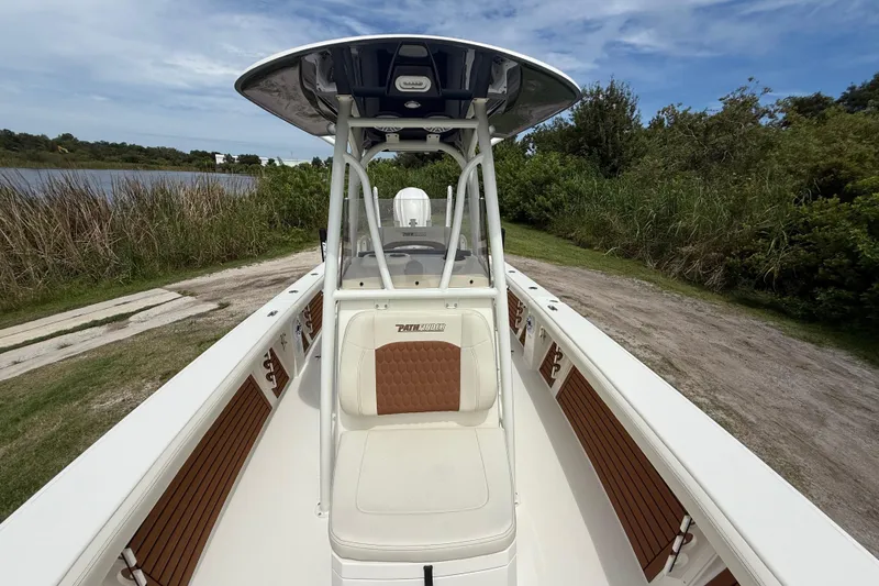 Slide: The Image of 2026 Pathfinder 2700 Open boat with seating, docked near lush greenery and water. - 19