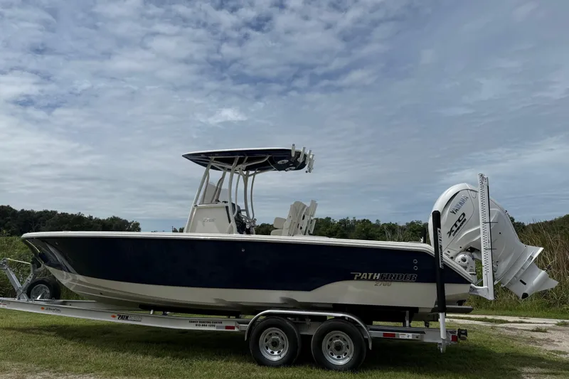 Slide: The Image of 2026 Pathfinder 2700 Open boat on trailer, under cloudy sky. - 2
